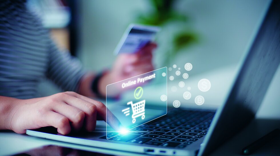 Umschulung Fachassistent/-in E-Commerce Jemand sitzt an einem Laptop und hat eine EC-Karte in der Hand
