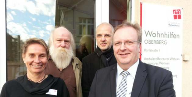 Eine Frau und drei Männer stehen vor dem Büro der Wohnhilfen Oberberg.