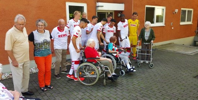 Spieler des 1. FC Köln mit Besuchern des Katharina-von-Bora-Hauses
