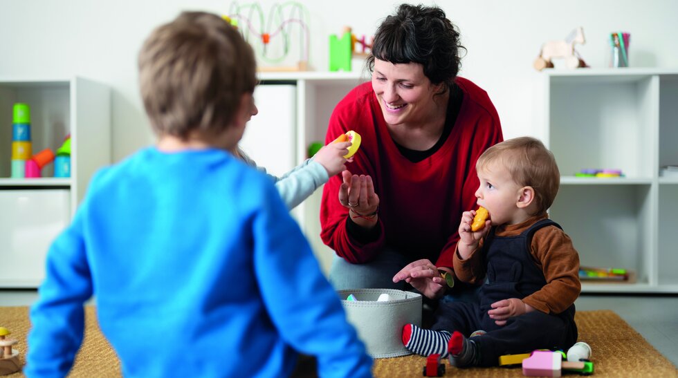 Eine Frau spielt mit zwei Kindern