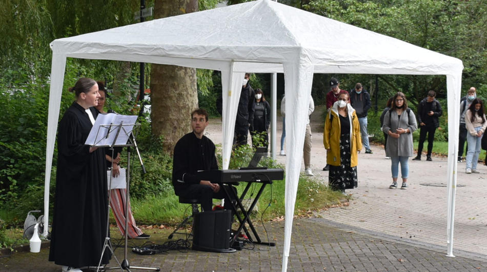 Die Schulpfarrerin hält einen Gottesdienst im Freien.