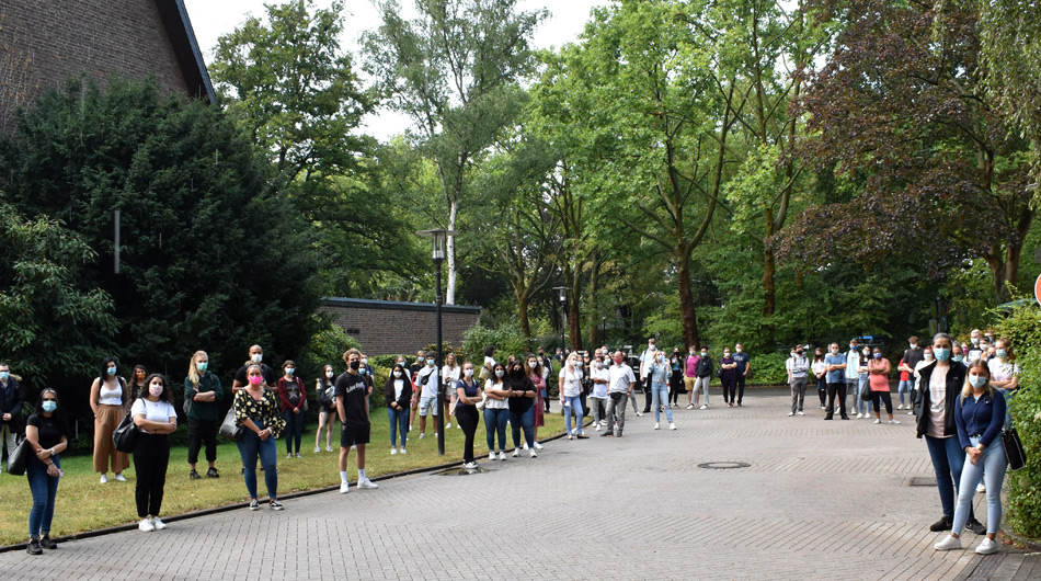 Schülerinnen und Schüler stehen mit Abstand vor dem Berufskolleg Michaelshoven.
