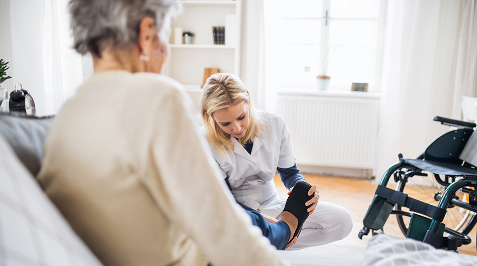 Eine pflergerin und eine Seniorin bei der Versorgung