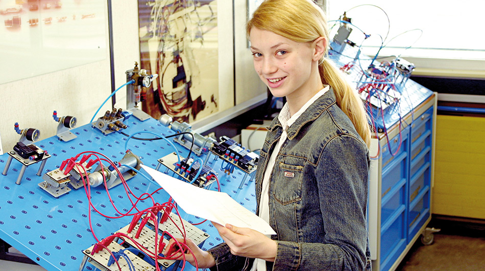 Eine junge Frau vor Schaltbrett mit Kabeln