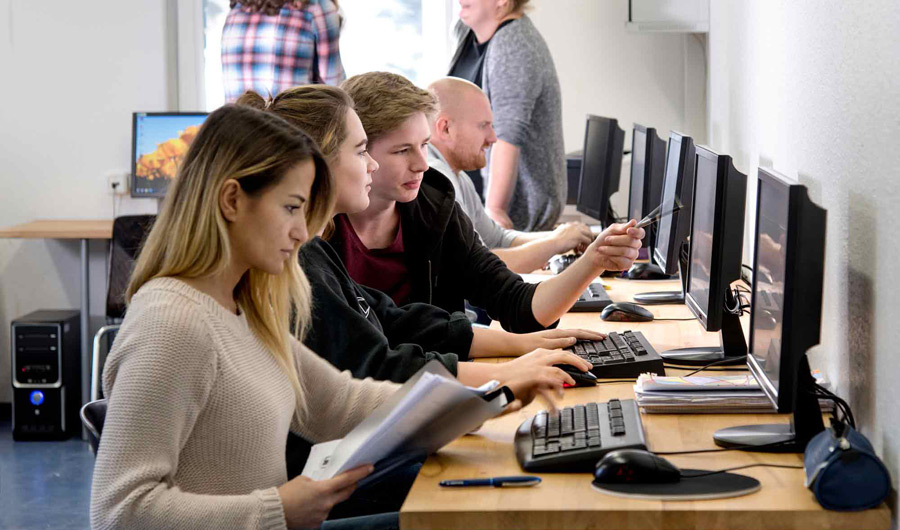 Mehrere Schüler des Berufskolleg Michaelshoven arbeiten an PCs.