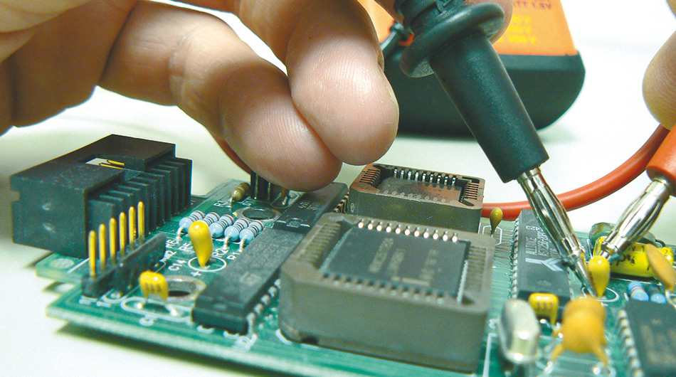 Ein Elektroniker für Geräte und Systeme arbeitet mit einem Schraubenzieher
