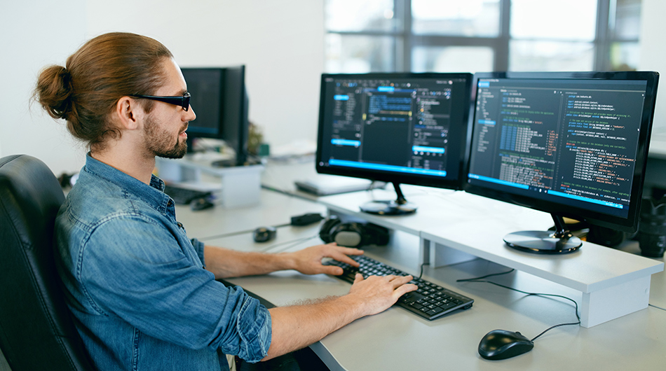 Umschulung IT-Systemelektroniker im BFW Köln Ein IT-Systemelektroniker vor zwei Monitoren