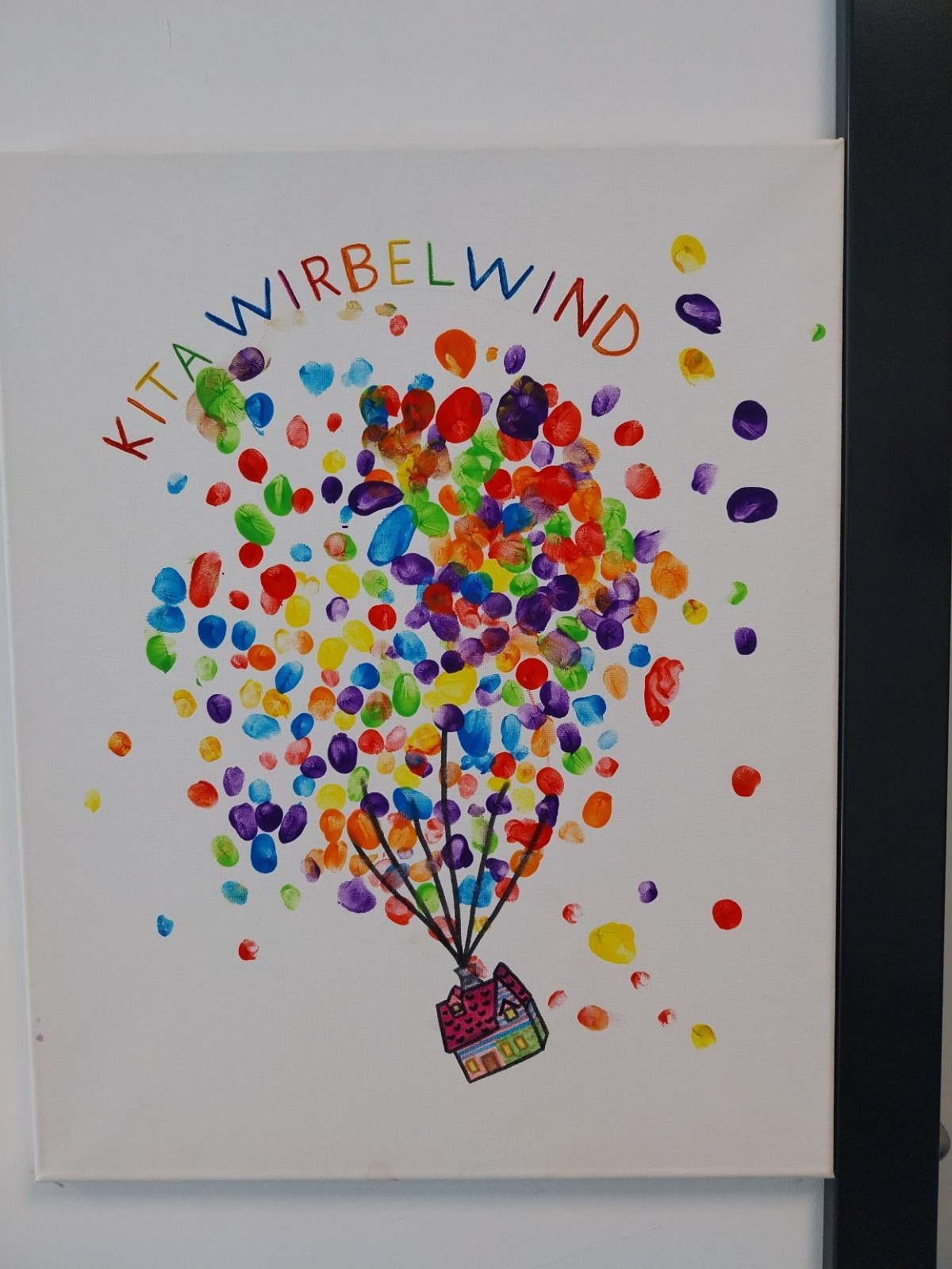 Ein buntes Schild mit Kita Wirbelwind Aufschrift