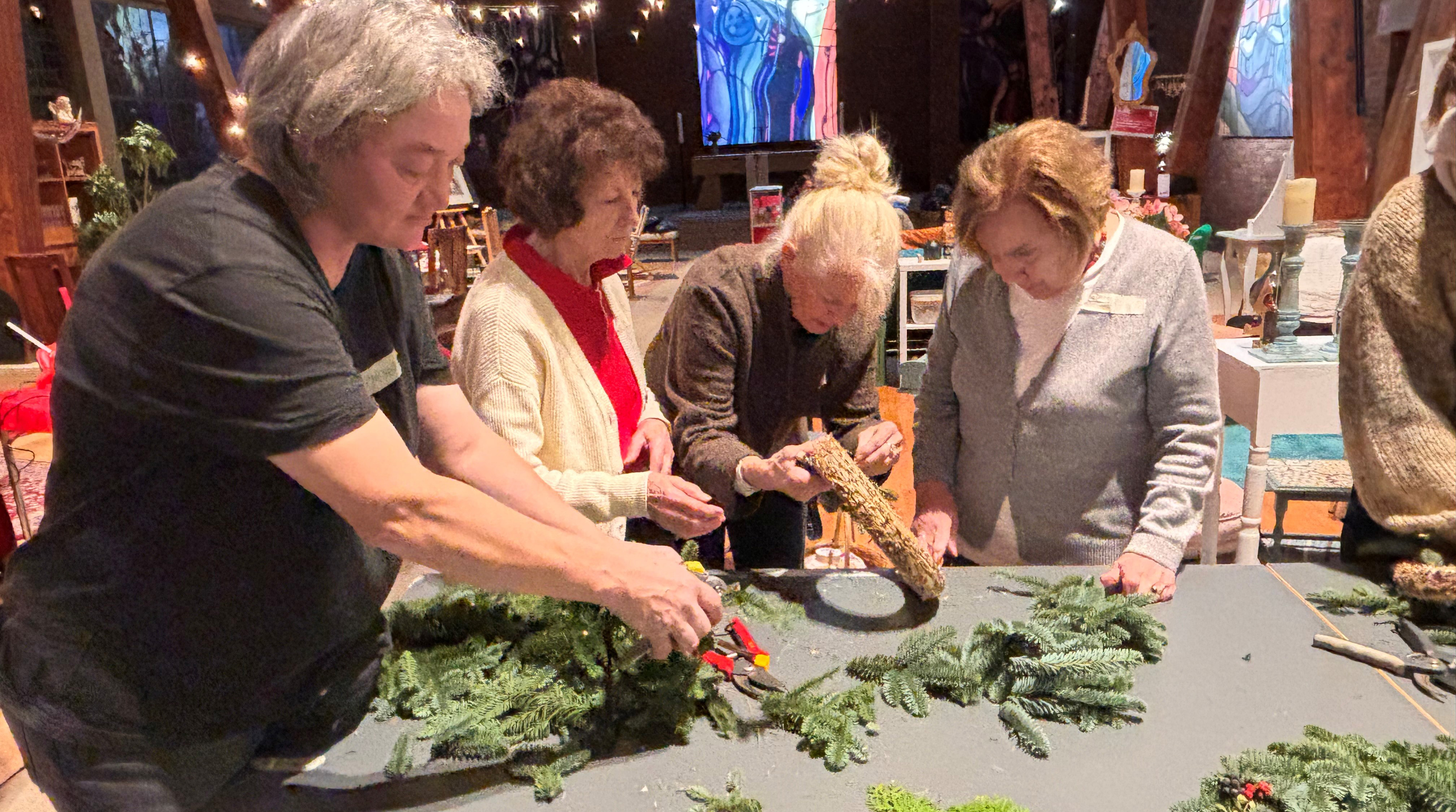 Adventskranzbasteln Mehrere Frauen basteln einen Adventskranz