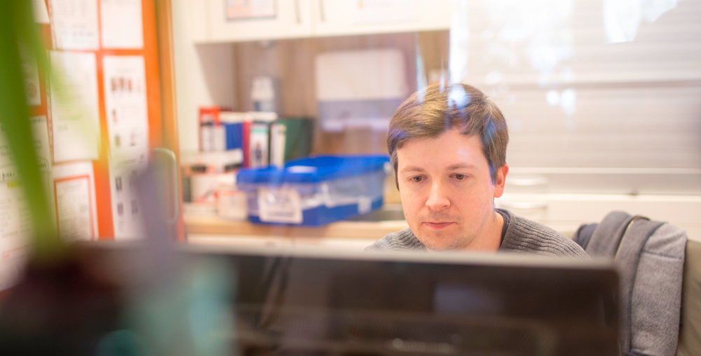 Philip Fischbach Ein Mann sitzt vor einem Monitor