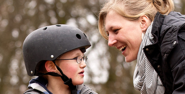 Eine junge Frau mit einem Jungen mit Fahrradhelm