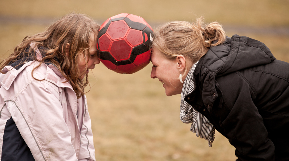 Eine Frau und ein Mädchen aus Michaelshoven, die mit der Stirn einen Ball zwischen sich halten